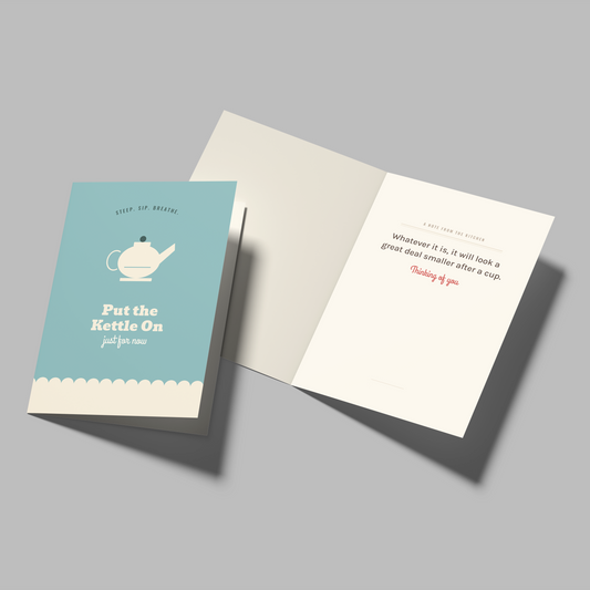 A greeting card set shown on a neutral gray background, featuring one closed card with a light blue front and one open card showing a white interior with printed text.