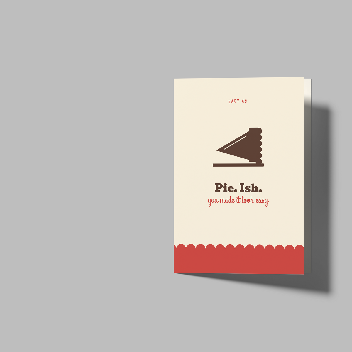 A set of blank white greeting cards and a printed sample card on a plain gray background. The sample card features a small brown cake slice illustration, the text 'Pist.