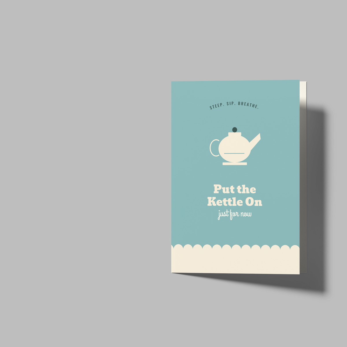 A set of blank greeting cards and a small printed card shown on a plain gray background. The set includes one closed card standing upright, one open card showing both front and back, and one small card with a teal background, a white teapot illustration, and the text 'Put the Kettle On' and 'polite.